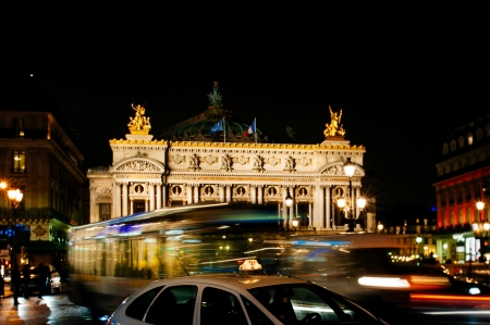 City Bus and Taxi passing in front of the Palais Garnier - Opera Garnier   The National Academy of Music -  illuminated at night in Paris, Franceのeditorial素材