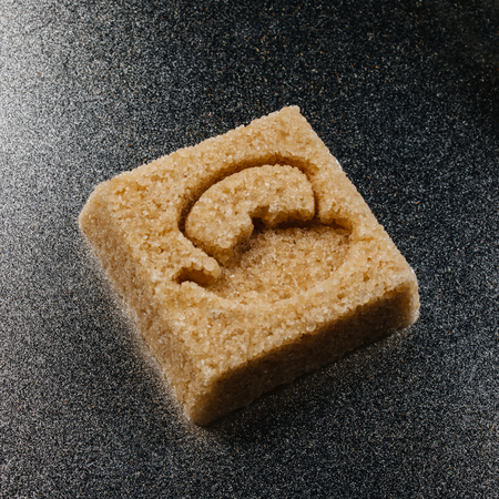 Sugar cube made of brown sugar with the shape of a tea or keetleon metallic の写真素材