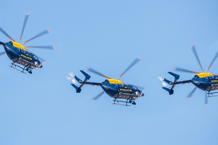 Police helicopter squadron flying against a clear blue skyのeditorial素材