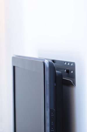 LCD / Plasma / Monitor wall mount with a modern unit attached to a white wall. Subtle blue technological color castの写真素材