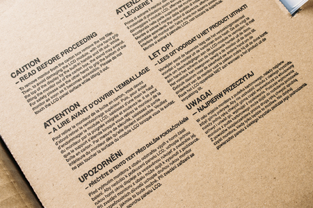 Caution notes on standard monitor cardboard box with inscriptions in diverse languages - close-upの写真素材