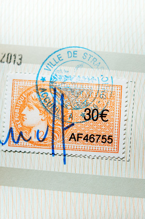 PARIS, FRANCE - APRIL 10, 2014: Revenue stamp or tax stamp or fiscal stamp issued by Republic of France in a value of 30 Euros, marked with a seal and signature as seen on a document on April 10, 2014のeditorial素材
