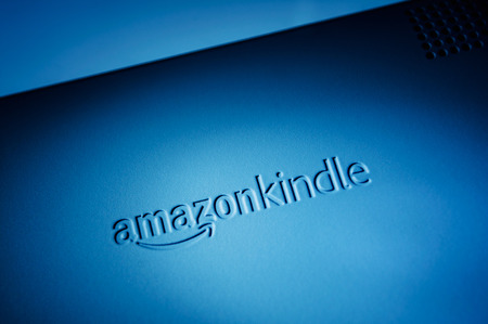 CUPERTINO, UNITED STATES - FEBRUARY 11, 2012: Studio shot of Kindle Reader logo from Amazon.com back side On February 11, 2012. Amazon Kindle devices enable users to shop for, download, browse, and read e-books, newspapers, magazines, blogs, and other digのeditorial素材