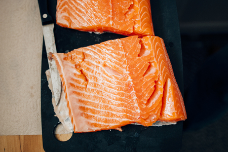 Salmon on kitchen plate ready for preparationの写真素材