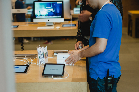 STRASBOURG, FRANCE - SEPTEMBER 19, 2014: An Apple Inc. genius employee assists a customer with the purchase during the sales launch of the iPhone 6 and iPhone 6 Plus at the company's Place Kleber store in France. Thousands of people waited next to Apple Sのeditorial素材