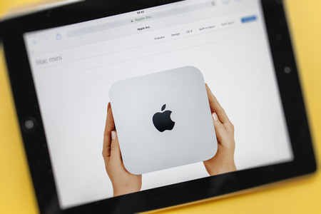 PARIS, FRANCE - 17 OCTOBER 2014: Photo of Apple iPad tablet with apple.com webpage of the new Mac Mini. Apple unveiled the new iPad Air 2 and iPad Mini 3, iMac with 5K Retina display and the new Mac Miniのeditorial素材