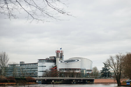 The  European Union Flag flies at half-mast on top of the European Court of Human rights in Strasbourg on January 8, 2015 following an attack the day before against French satirical weekly newspaper Charlie Hebdo offices in Paris which left 12 people deadのeditorial素材