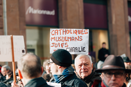 STRASBOURG, FRANCE - 11 JAN, 2015:  People hold placards reading 'Catholics, muslims, jews all are Charlie' during a unity rally (Marche Republicaine) where some 50000 people took part in tribute three-day killing spree in Parisのeditorial素材