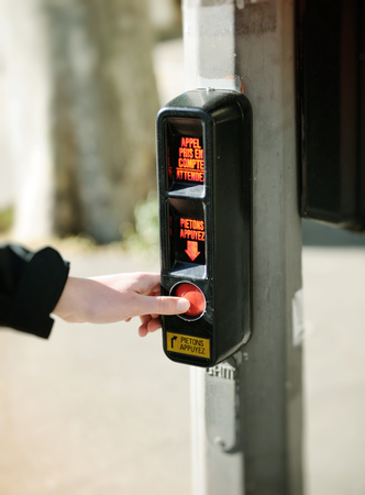 Pressing vintage button for crossing the street on a crosswalk.の写真素材