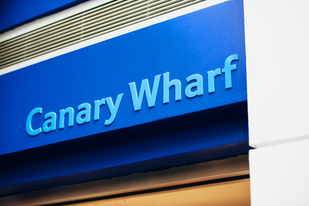 Canary Wharf sign in the named business district of London on the River Thames, is surrounded by the three tallest buildings in the United Kingdom.のeditorial素材