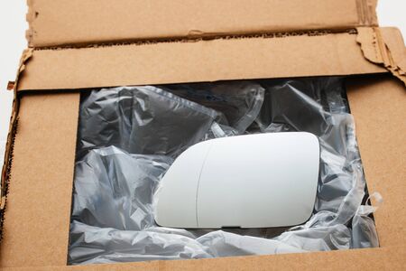 Car mirror in box - new object delivered in cardboard box with air protection platiscの写真素材