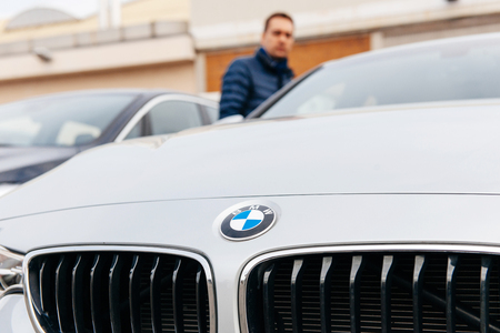 MUNCHEN, GERMANY - APRIL 06, 2015: Man looking at electric BMW limousine outside car dealership.のeditorial素材