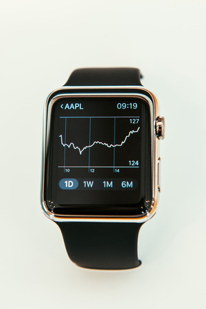PARIS, FRANCE â APR 10, 2015: New wearable computer Apple Watch smartwatch displaying the new Stocks App with Apple Stock Price Graph. Apple Watch incorporates fitness tracking and health-oriented capabilities and  integration with iOS Apple products anのeditorial素材