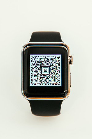 PARIS, FRANCE â APR 10, 2015: New wearable computer Apple Watch smartwatch displaying the new Passbook App with QR code. Apple Watch incorporates fitness tracking and health-oriented capabilities and  integration with iOS Apple products and servicesのeditorial素材