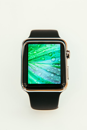 PARIS, FRANCE â APR 10, 2015: New wearable computer Apple Watch smartwatch displaying the new Photo App. Apple Watch incorporates fitness tracking and health-oriented capabilities and  integration with iOS Apple products and servicesのeditorial素材