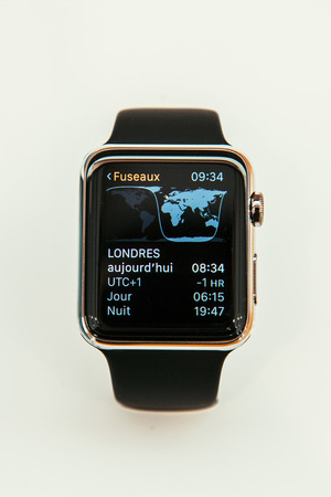 PARIS, FRANCE â APR 10, 2015: New wearable computer Apple Watch smartwatch displaying the new Time Zone App. Apple Watch incorporates fitness tracking and health-oriented capabilities and  integration with iOS Apple products and servicesのeditorial素材