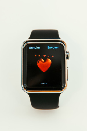 PARIS, FRANCE â APR 10, 2015: New wearable computer Apple Watch smartwatch displaying the new  Love Emoji. Apple Watch incorporates fitness tracking and health-oriented capabilities and  integration with iOS Apple products and servicesのeditorial素材