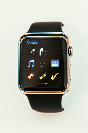 PARIS, FRANCE â APR 10, 2015: New wearable computer Apple Watch smartwatch displaying the new musical instruments emoji. Apple Watch incorporates fitness tracking and health-oriented capabilities and  integration with iOS Apple products and servicesのeditorial素材