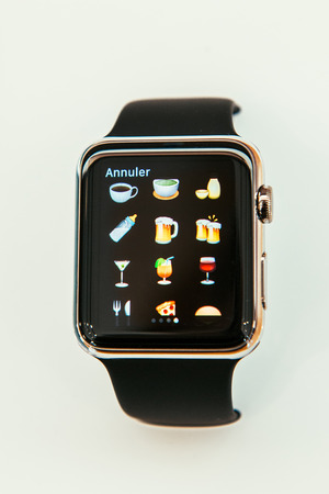 PARIS, FRANCE â APR 10, 2015: New wearable computer Apple Watch smartwatch displaying the new  food and drinks emoji. Apple Watch incorporates fitness tracking and health-oriented capabilities and  integration with iOS Apple products and servicesのeditorial素材