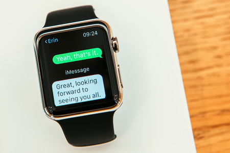 PARIS, FRANCE â APR 10, 2015: New wearable computer Apple Watch smartwatch displaying the new Message App. Apple Watch incorporates fitness tracking and health-oriented capabilities and  integration with iOS Apple products and servicesのeditorial素材