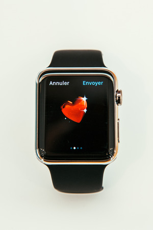 PARIS, FRANCE â APR 10, 2015: New wearable computer Apple Watch smartwatch displaying the new Love Emoji. Apple Watch incorporates fitness tracking and health-oriented capabilities and  integration with iOS Apple products and servicesのeditorial素材