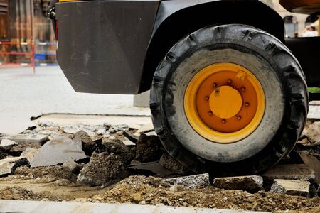 Truck tire on a broken asphalt at construction site in urban environmentの写真素材