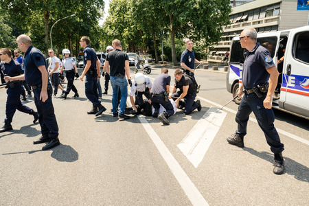 STRASBOURG, FRANCE - JULY 11, 2015: Police arresting man - Uyghur human rights activists participate in a demonstration to protest against Chinese government's policy in Uyghurのeditorial素材
