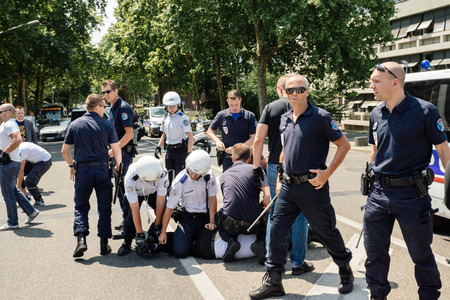 STRASBOURG, FRANCE - JULY 11, 2015: Police arresting man - Uyghur human rights activists participate in a demonstration to protest against Chinese government's policy in Uyghurのeditorial素材