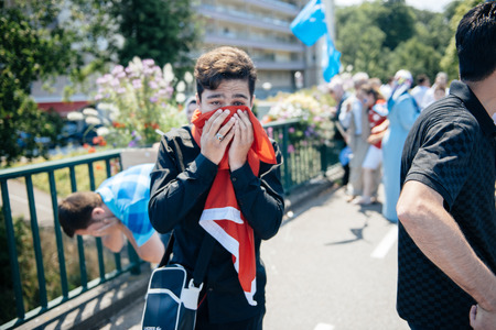 STRASBOURG, FRANCE - JULY 11, 2015: Protestor cries after being pepper sprayed - Uyghur human rights activists participate in a demonstration to protest against Chinese government's policy in Uyghurのeditorial素材