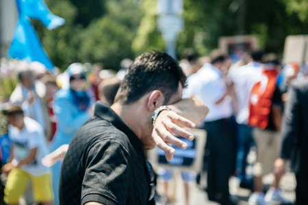 STRASBOURG, FRANCE - JULY 11, 2015: Protestor cries after being pepper sprayed - Uyghur human rights activists participate in a demonstration to protest against Chinese government's policy in Uyghurのeditorial素材