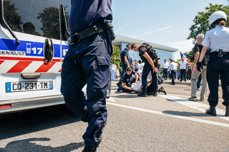 STRASBOURG, FRANCE - JULY 11, 2015: Police arresting man - Uyghur human rights activists participate in a demonstration to protest against Chinese government's policy in Uyghurのeditorial素材