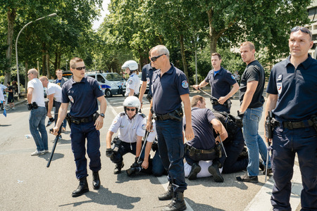 STRASBOURG, FRANCE - JULY 11, 2015: Police arresting man - Uyghur human rights activists participate in a demonstration to protest against Chinese government's policy in Uyghurのeditorial素材