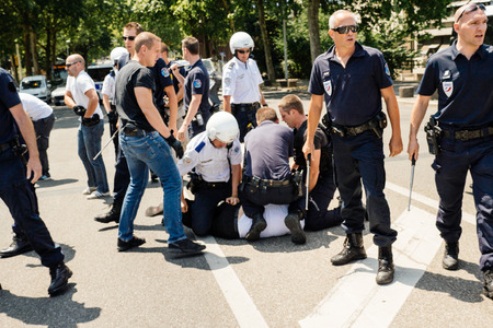 STRASBOURG, FRANCE - JULY 11, 2015: Police arresting man - Uyghur human rights activists participate in a demonstration to protest against Chinese government's policy in Uyghurのeditorial素材