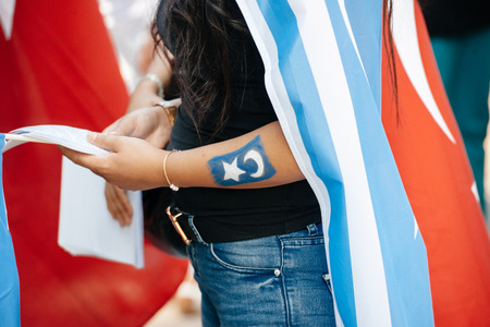 STRASBOURG, FRANCE - JULY 11, 2015: East Turkestan flag tatoo - Uyghur human rights activists participate in a demonstration to protest against Chinese government's policy in Uyghurのeditorial素材
