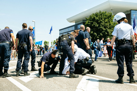 STRASBOURG, FRANCE - JULY 11, 2015: Police arresting man - Uyghur human rights activists participate in a demonstration to protest against Chinese government's policy in Uyghurのeditorial素材