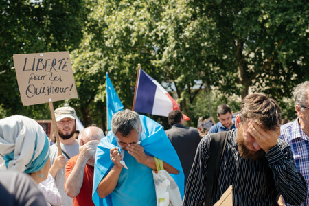 STRASBOURG, FRANCE - JULY 11, 2015: Protestor cries after being pepper sprayed - Uyghur human rights activists participate in a demonstration to protest against Chinese government's policy in Uyghurのeditorial素材