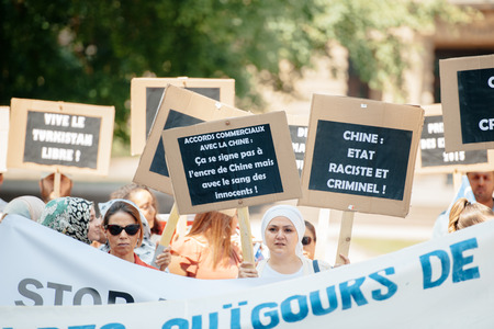 STRASBOURG, FRANCE - JULY 11, 2015: China rasist and crimial country placard - Uyghur human rights activists participate in a demonstration to protest against Chinese government's policy in Uyghurのeditorial素材