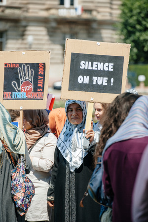 STRASBOURG, FRANCE - JULY 11, 2015: Silent killing placard - Uyghur human rights activists participate in a demonstration to protest against Chinese government's policy in Uyghurのeditorial素材
