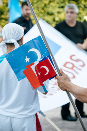 STRASBOURG, FRANCE - JULY 11, 2015: East Turkistan flag and Turkey flag - Uyghur human rights activists participate in a demonstration to protest against Chinese government's policy in Uyghurのeditorial素材
