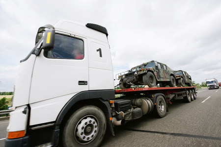 Frankfurt am Main, Germany - July 4, 2011: Truck carrying lightweight armored vehicles on a public highway.のeditorial素材