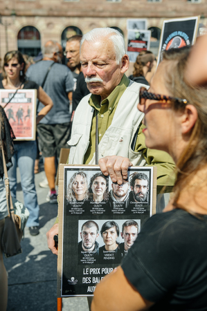 STRASBOURG, FRANCE - AUG 22, 2015: Marine conservation non-profit organization Sea Shepherd protesting against the slaughter of pilot whales and arrest of 7 crew members - man holding placard with arested peopleのeditorial素材
