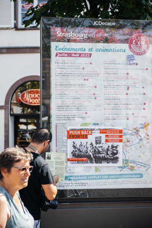 People protesting against immigration policy and border management which asks for commitment in the wake of migrants boat disasters - man putting placards on public mapのeditorial素材