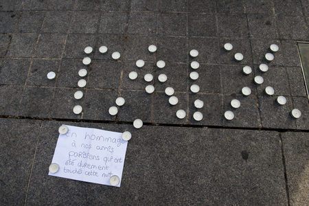 STRASBOURG, FRANCE - 14 NOV 2015: Light candles near General Kleber statue in tribute to the victims of the terrorist attacks in Paris - people writing PEACE word with candlesのeditorial素材