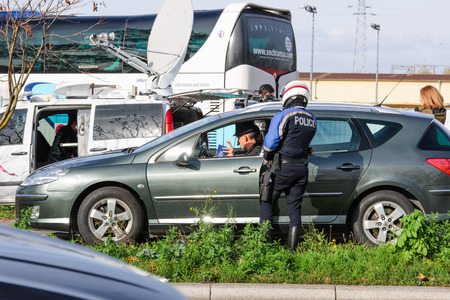 STRASBOURG, FRANCE - NOV 14 2015: French Police checking vehicles on the 'Bridge of Europe' between Strasbourg and Kehl Germany, as a security measure in the wake of attacks in Paris - officer body searching drivers, surveillanceのeditorial素材