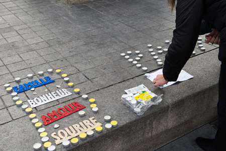 STRASBOURG, FRANCE - 14 NOV 2015: Light candles near General Kleber statue in tribute to the victims of the terrorist attacks in Paris - people writing PEACE word with candlesのeditorial素材