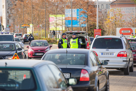 STRASBOURG, FRANCE - NOV 14 2015: French Police checking vehicles on the 'Bridge of Europe' between Strasbourg and Kehl Germany, as a security measure in the wake of attacks in Paris - two officers inspecting carsのeditorial素材