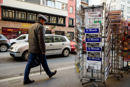 STRASBOURG, FRANCE - 16 NOV, 2015: Man passing near front covers pf Le Monde newspaper magazine display headlining the terrorist attacks in Paris on 13 Novemberのeditorial素材