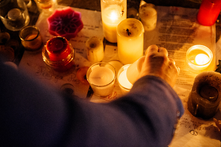 STRASBOURG, FRANCE - NOV 18, 2015: Woman lights candles in center of Strasbourg, in solidarity for victims and families of the assault in Parisのeditorial素材