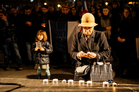 STRASBOURG, FRANCE - NOV 18, 2015: Woman lights candles in center of Strasbourg, in solidarity for victims and families of the assault in Parisのeditorial素材