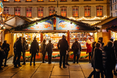 Busy Christmas Market Christkindlmarkt in the city of Strasbourg, Alsace region,  France with people admiring gifts at kioskのeditorial素材